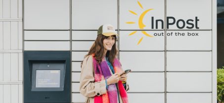 Uśmiechnięta kobieta stoi na tle paczkomatu inpost. Nie tylko e-commerce. Jak Paczkomaty zaczęły wspierać bezpieczeństwo i NGO blog